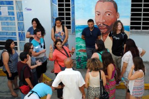 group of young people stand around a speaker